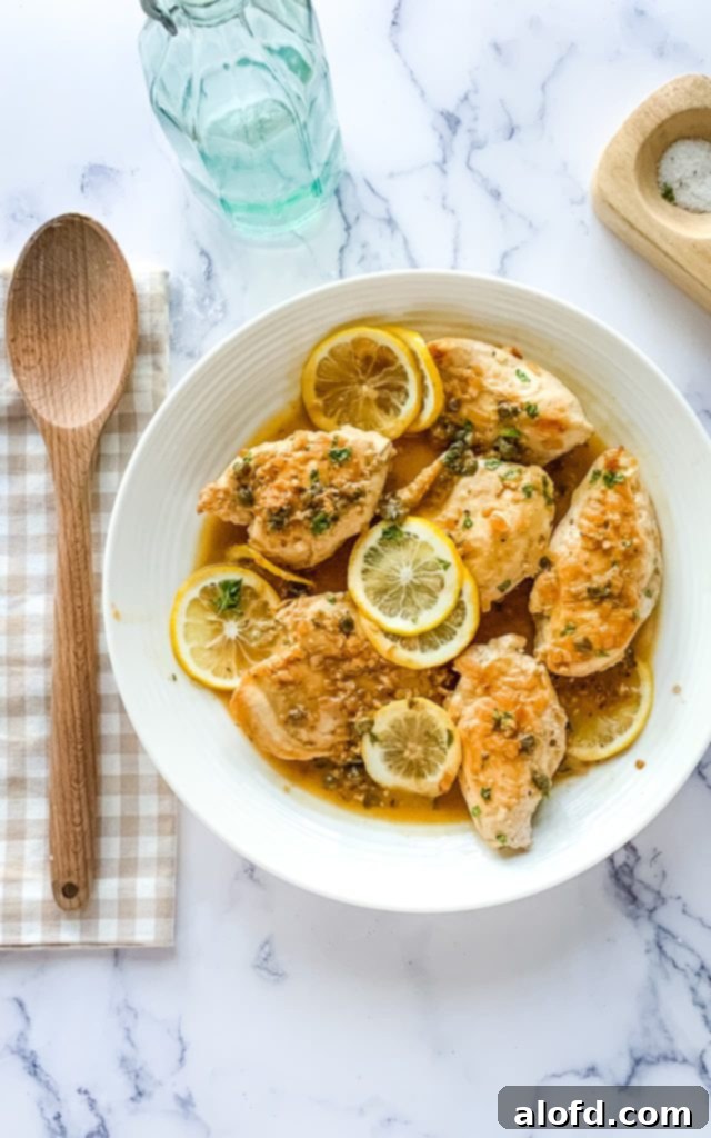The Feathered Nester's Food Quest 4 A beautifully plated dish of Chicken Piccata, garnished with fresh parsley and lemon slices, ready to be served as part of a meal challenge.