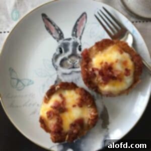 Crispy Tater Tot Egg Bites 7 Two tater tot egg nests, beautifully baked and garnished, sitting on a charming plate decorated with an Easter bunny. A perfect, festive breakfast or brunch item.