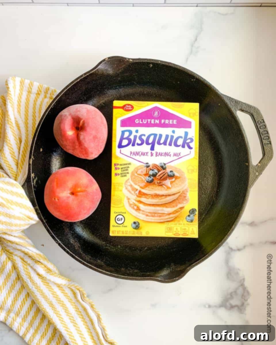 Easy Bisquick Peach Cobbler 4 Ingredients for gluten-free peach cobbler: a yellow box of Gluten-Free Bisquick and sliced peaches in a cast iron skillet, ready for baking.