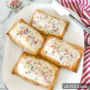 Untamed Berry Breakfast Pastries 11 a plate of frosted blueberry hand pies.