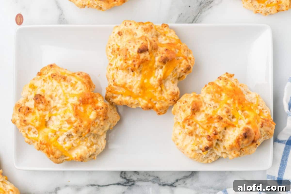 Bisquick Garlic Cheddar Biscuits 17 A wider shot of a wooden platter brimming with delicious, golden brown cheddar biscuits.