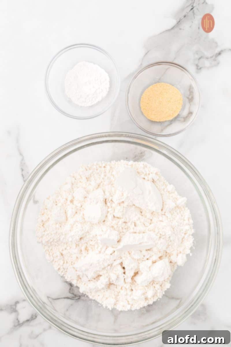 Bisquick Garlic Cheddar Biscuits 7 A bowl containing Bisquick mix, baking powder, and garlic powder, ready for mixing.