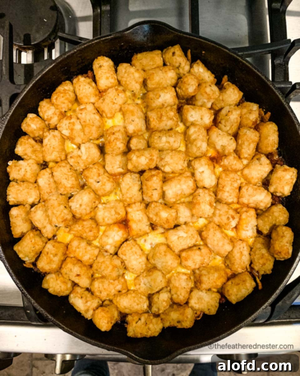 Crispy Tater Tot Green Bean Bake 6 A skillet of green bean casserole with tater tots, ready to go into the oven.
