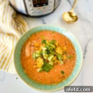 a square photo of a green bowl with Instant Pot Chicken Tortilla Soup with a striped yellow cloth, Instant Pot, and a golden spoon at the side.
