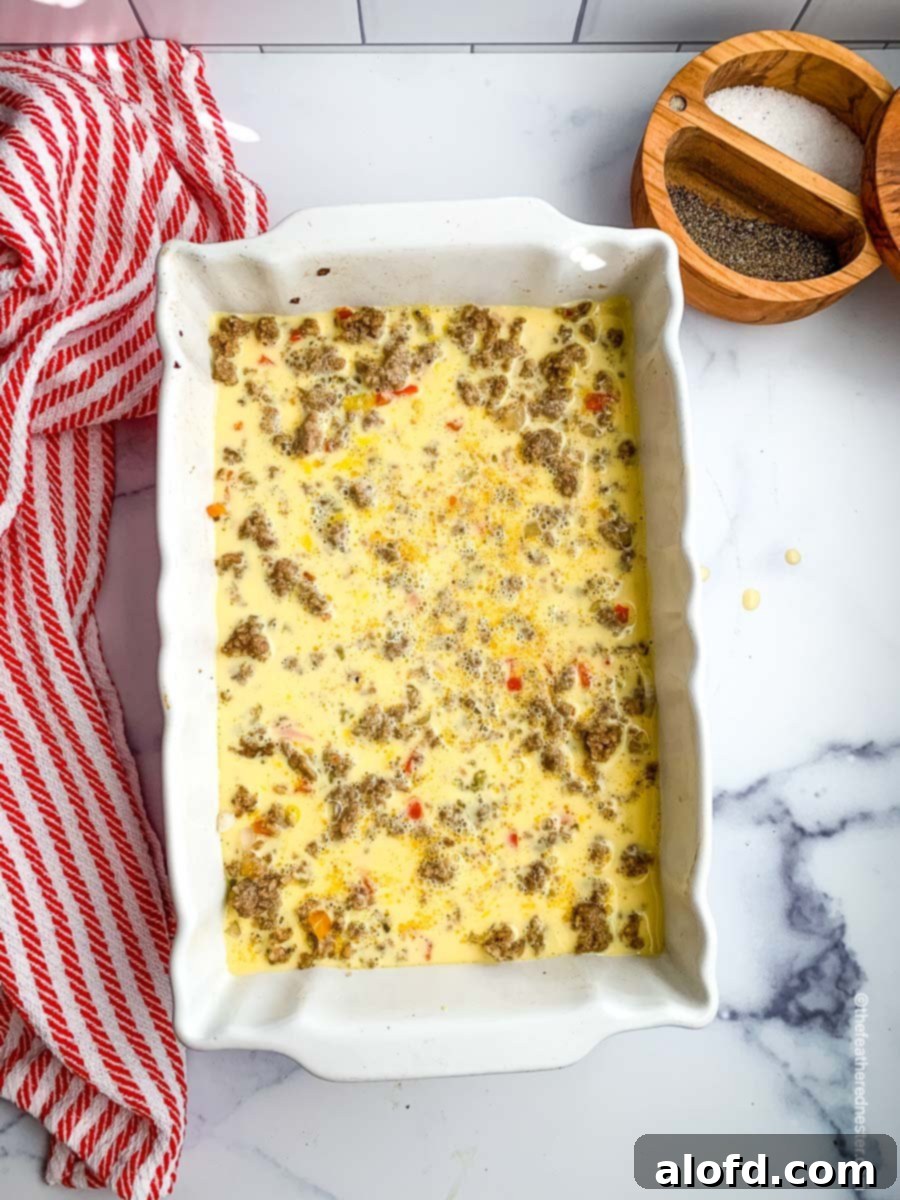 Ultimate Hash Brown Breakfast Bake 8 The casserole dish now filled with the egg and sausage mixture, ready for the final cheese layer and baking.