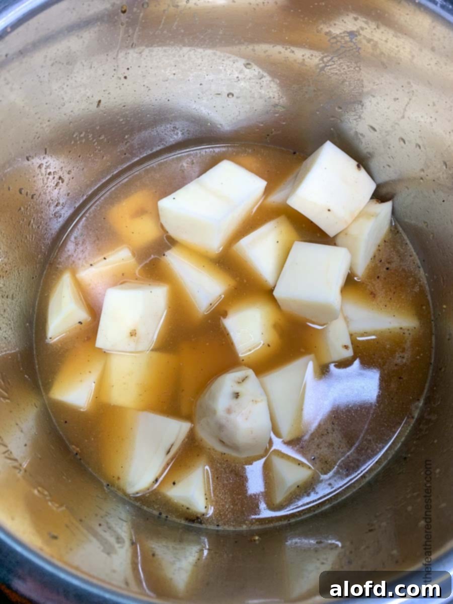 Juicy Instant Pot Turkey Tenderloin 6 Peeled and cubed potatoes, cooked in a pressure cooker with broth, ready to be mashed.