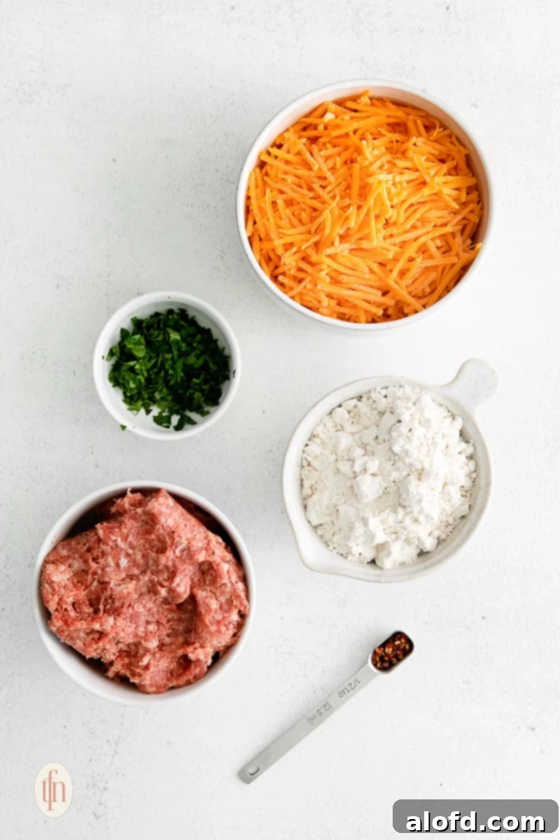 Bisquick Sausage Balls: Effortless Appetizer Perfection 3 Bowls filled with shredded cheese, Bisquick baking mix, ground breakfast sausage, and a small pile of chopped green onions and red pepper flakes.