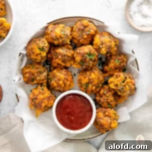 Bisquick Sausage Balls: Effortless Appetizer Perfection 10 Bisquick sausage balls on a large white platter with a small jar of dipping sauce on the side.