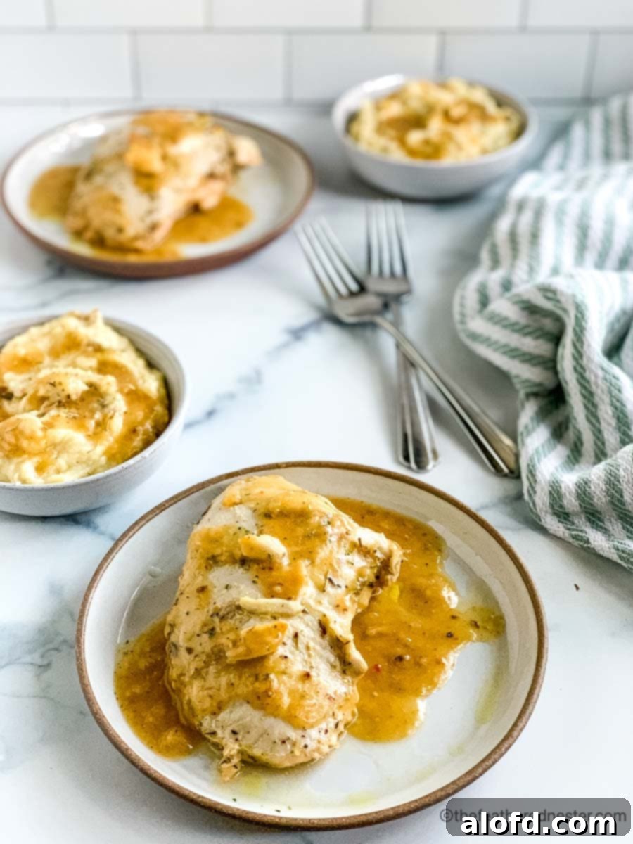 A plate of sliced turkey with bowls of mashed potatoes and gravy.