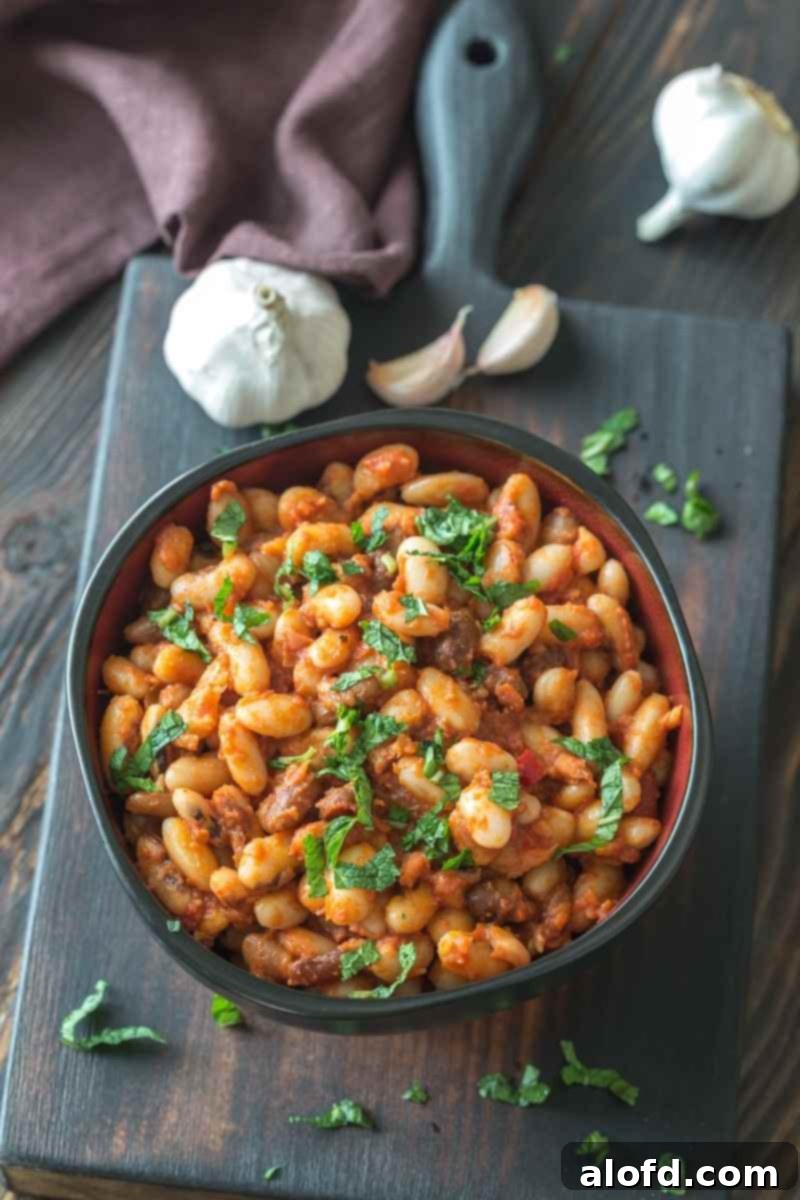 a bowl of calico beans on a wooden board.