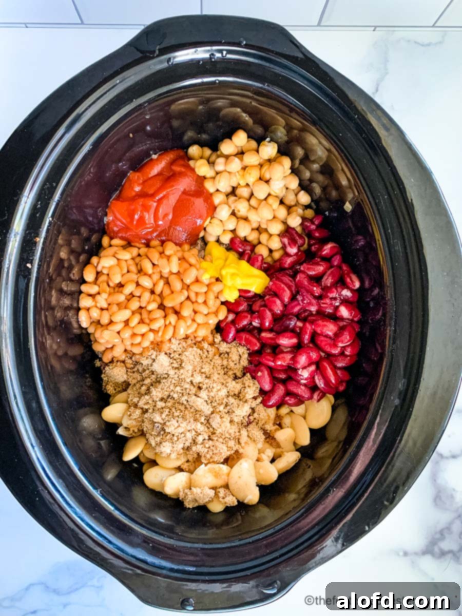 a slow cooker full of canned beans, ground beef, onions, and spices to make crock pot beans.