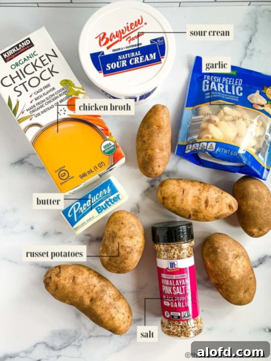 Creamy Instant Pot Garlic Mash 4 Labeled ingredients for Instant Pot garlic mashed potatoes including potatoes, garlic, broth, butter, and sour cream.