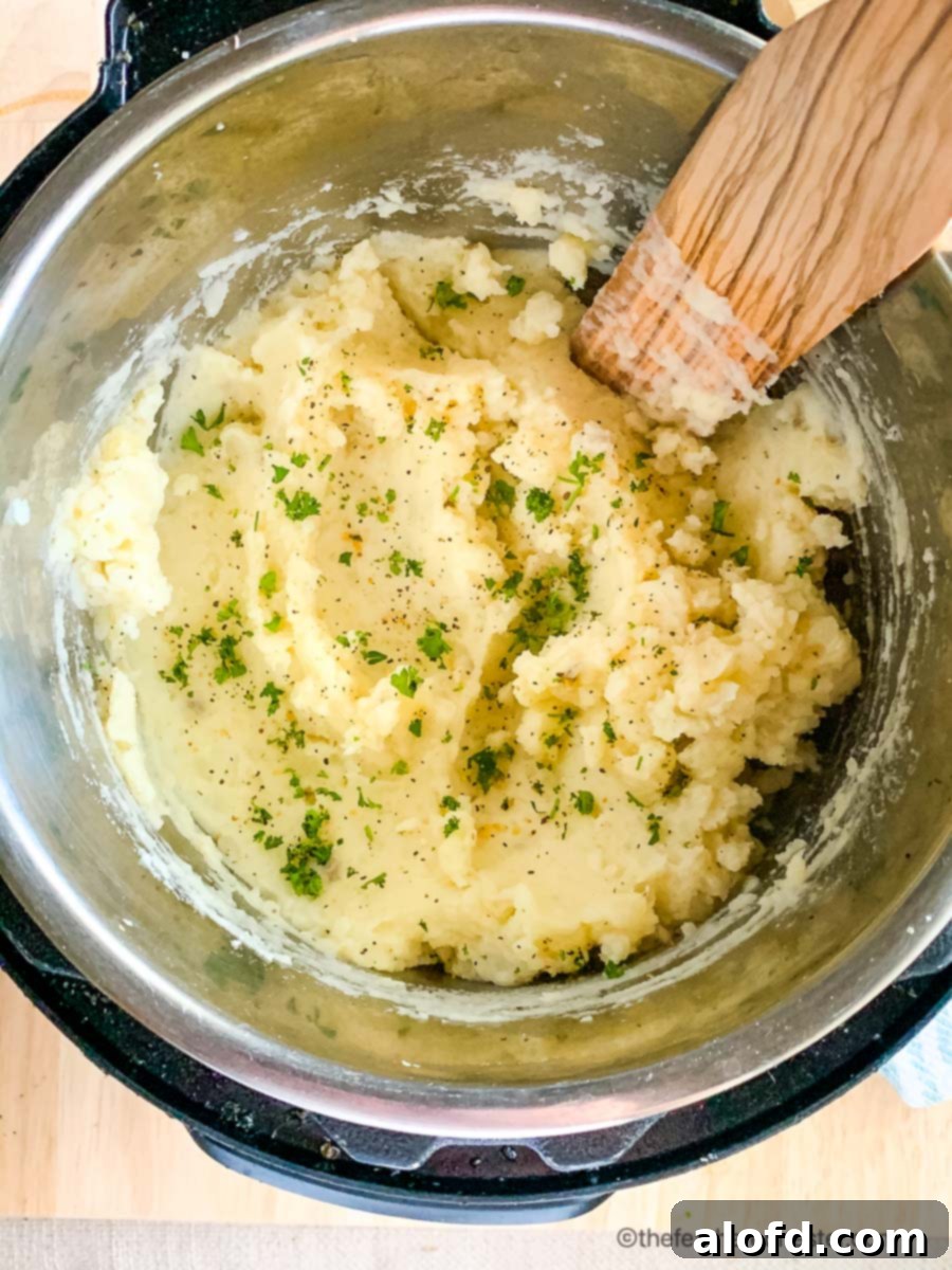 Creamy Instant Pot Garlic Mash 7 Fluffy garlic mashed potatoes garnished with fresh herbs in the Instant Pot, ready to be served.