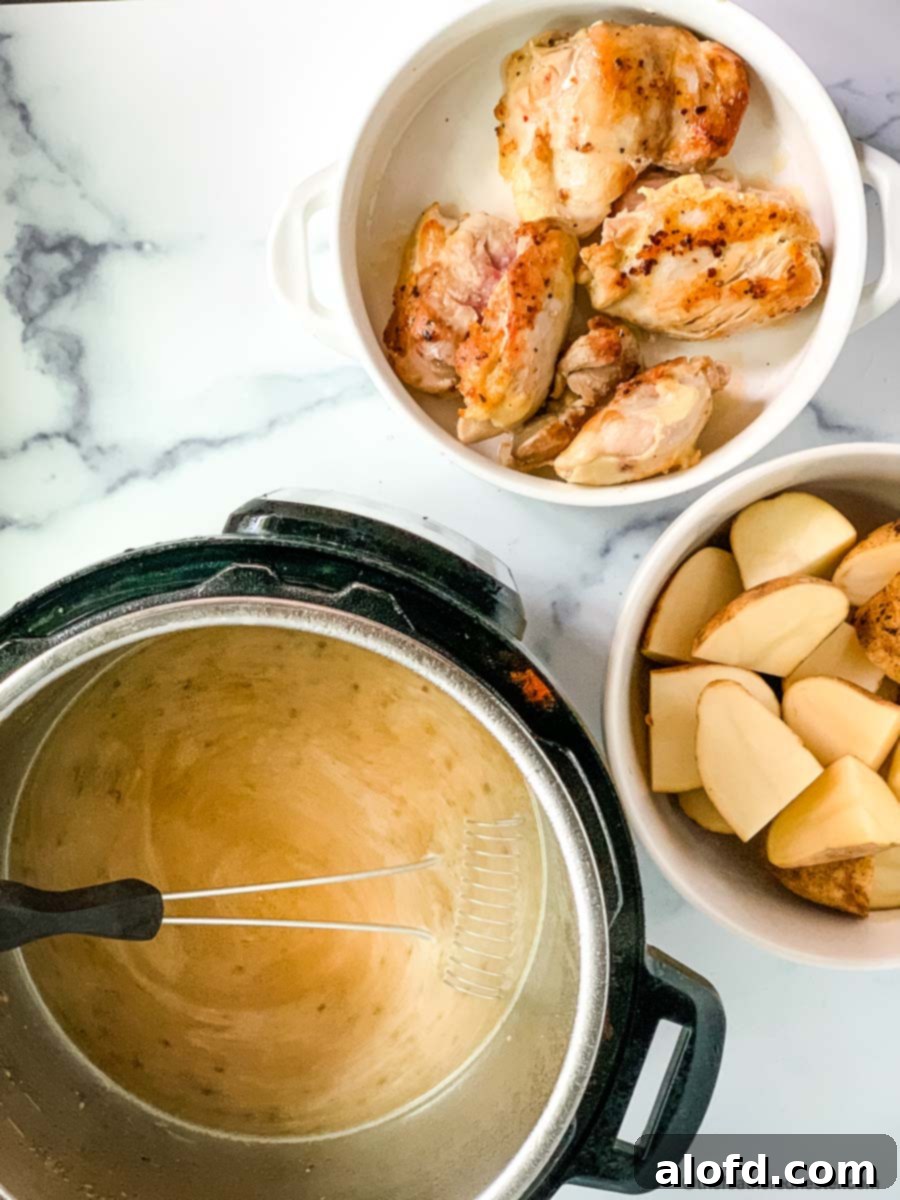Tender Instant Pot Chicken Thighs and Potatoes 5 Preparing chicken thighs and potatoes in the pressure cooker.
