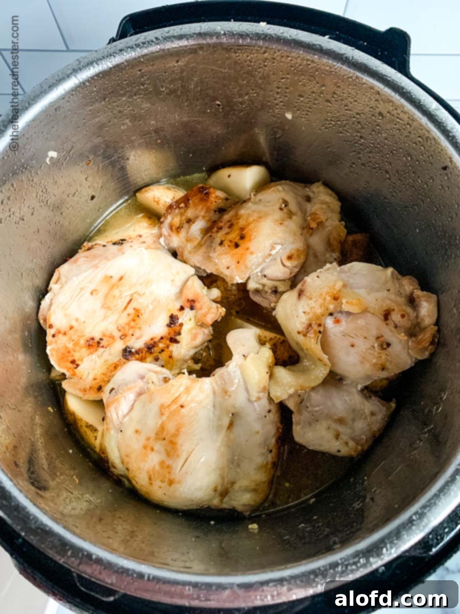 Tender Instant Pot Chicken Thighs and Potatoes 6 Chicken thighs searing in the pressure cooker.