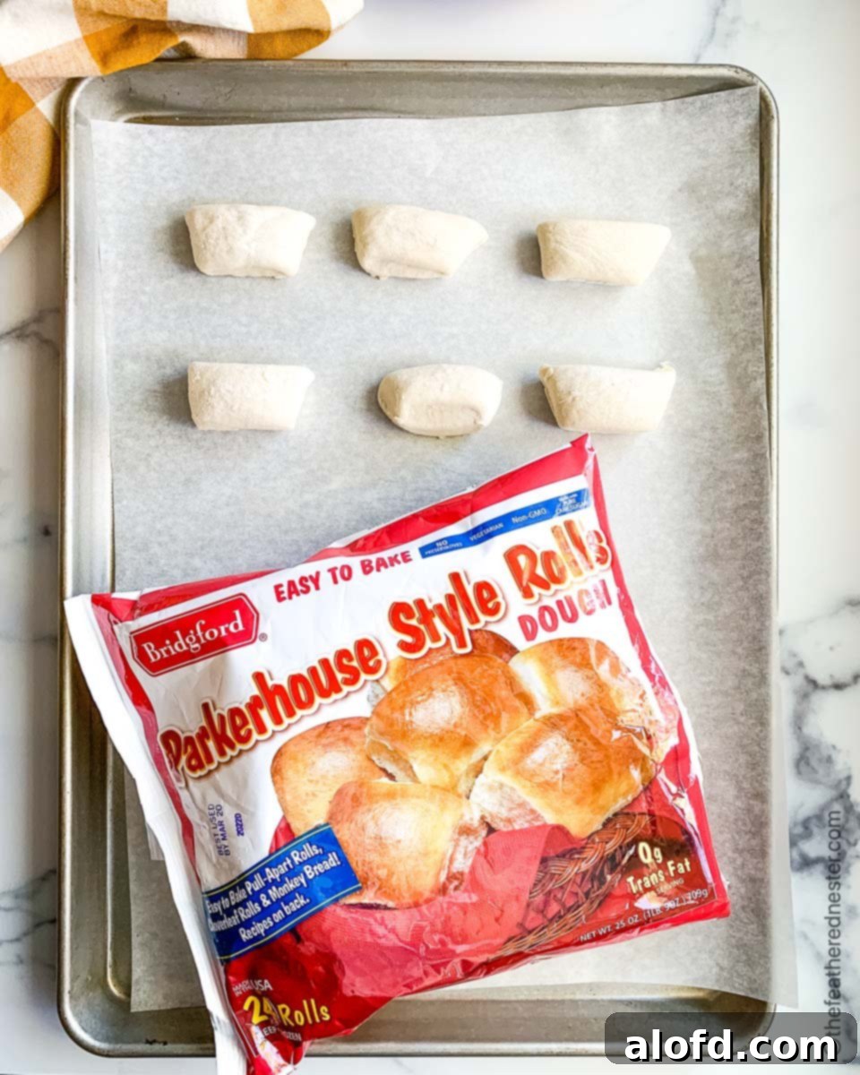 A baking sheet of frozen dough thawing, next to a bag of Bridgford Parker House style rolls.