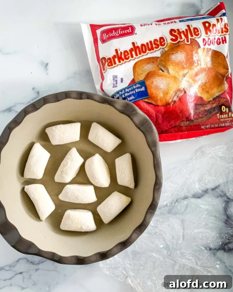 A pie plate of frozen Bridgford Parkerhouse Rolls thawing.