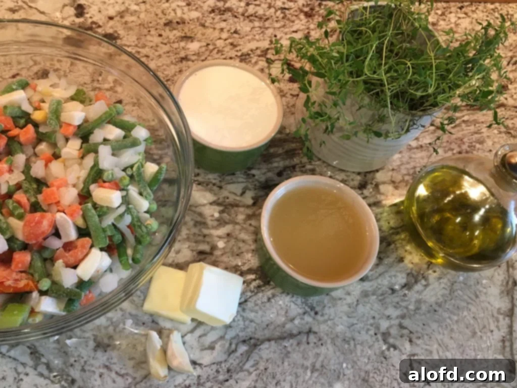 A selection of ingredients for chicken pot pie including olive oil, garlic, various vegetables, chicken broth, and cream.