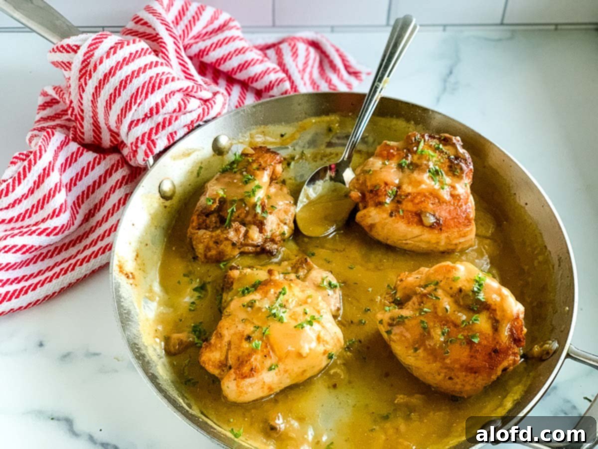 Homestyle Gravy Chicken Thighs 8 Perfectly cooked chicken thighs bathed in a rich, homemade pan gravy, served on a white plate and ready to be enjoyed.