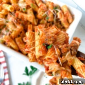 Baked rigatoni pasta casserole, shown closeup on a fork.
