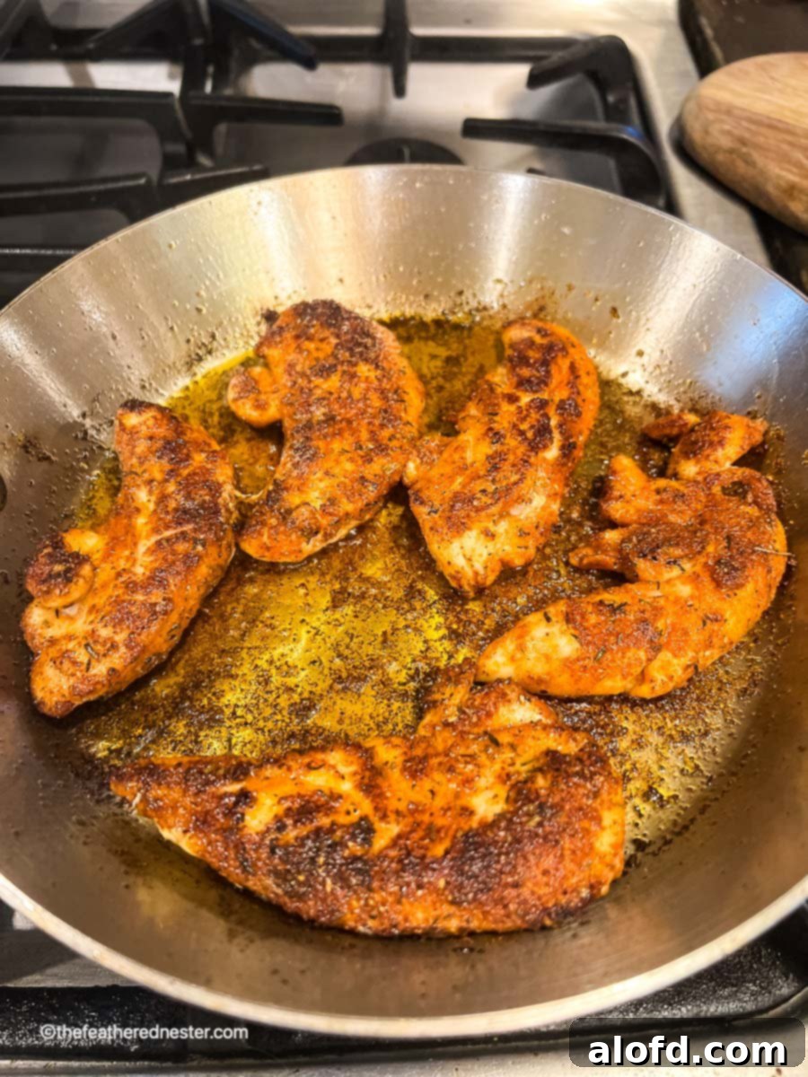 Cajun-Spiced Chicken Strips 3 blackening chicken in a skillet.