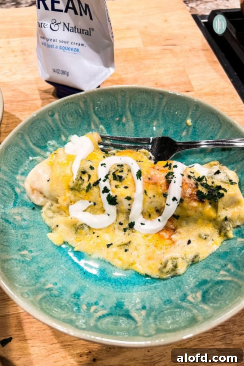 Luscious Sour Cream Chicken Enchiladas 3 Enchiladas in a bowl with fork.