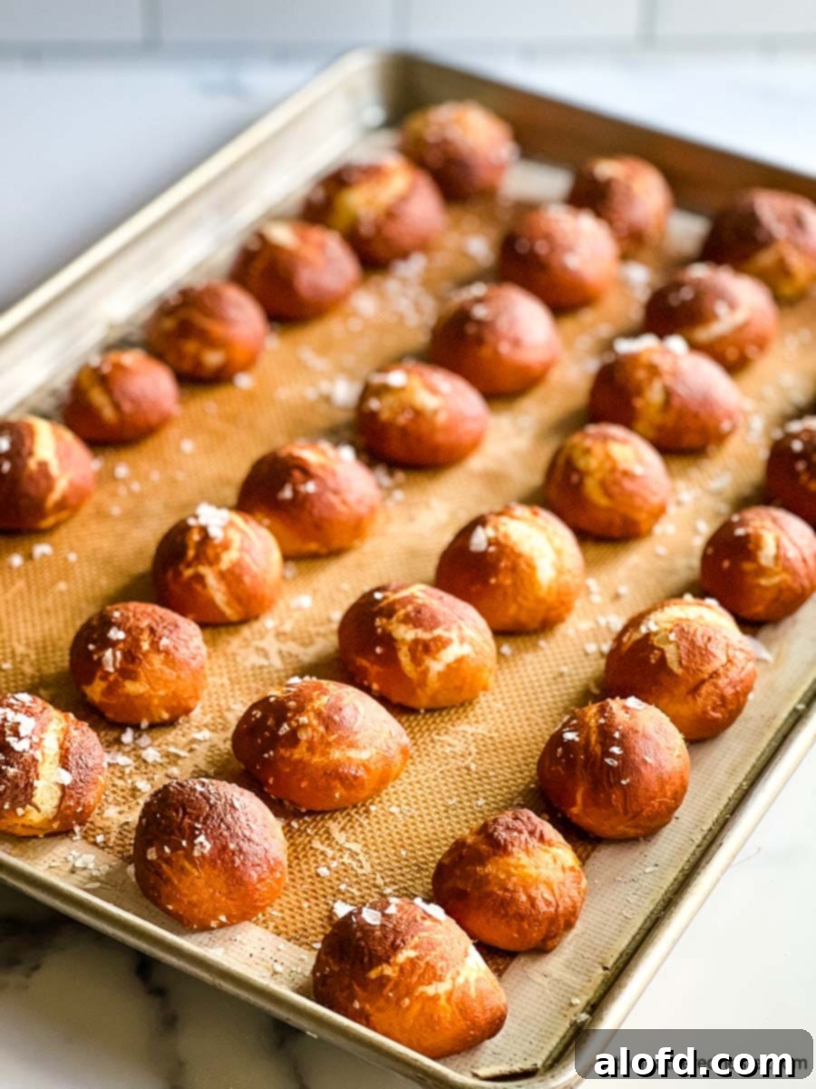 Pretzel Poppers 9 A tray of freshly baked soft pretzel bites, glistening and golden.