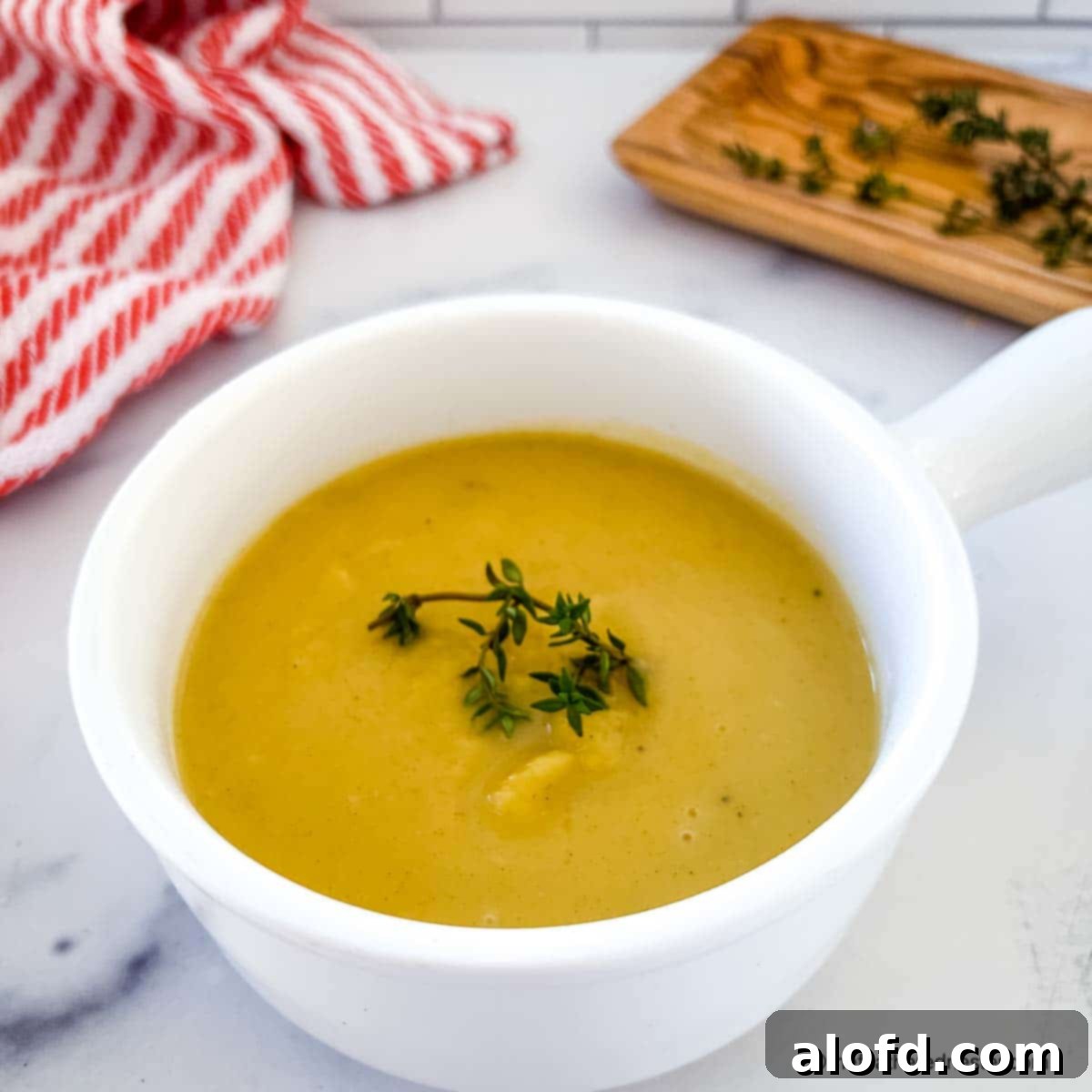 Creamy Instant Pot Acorn Squash Soup 12 A close-up shot of creamy acorn squash soup in a bowl, garnished.