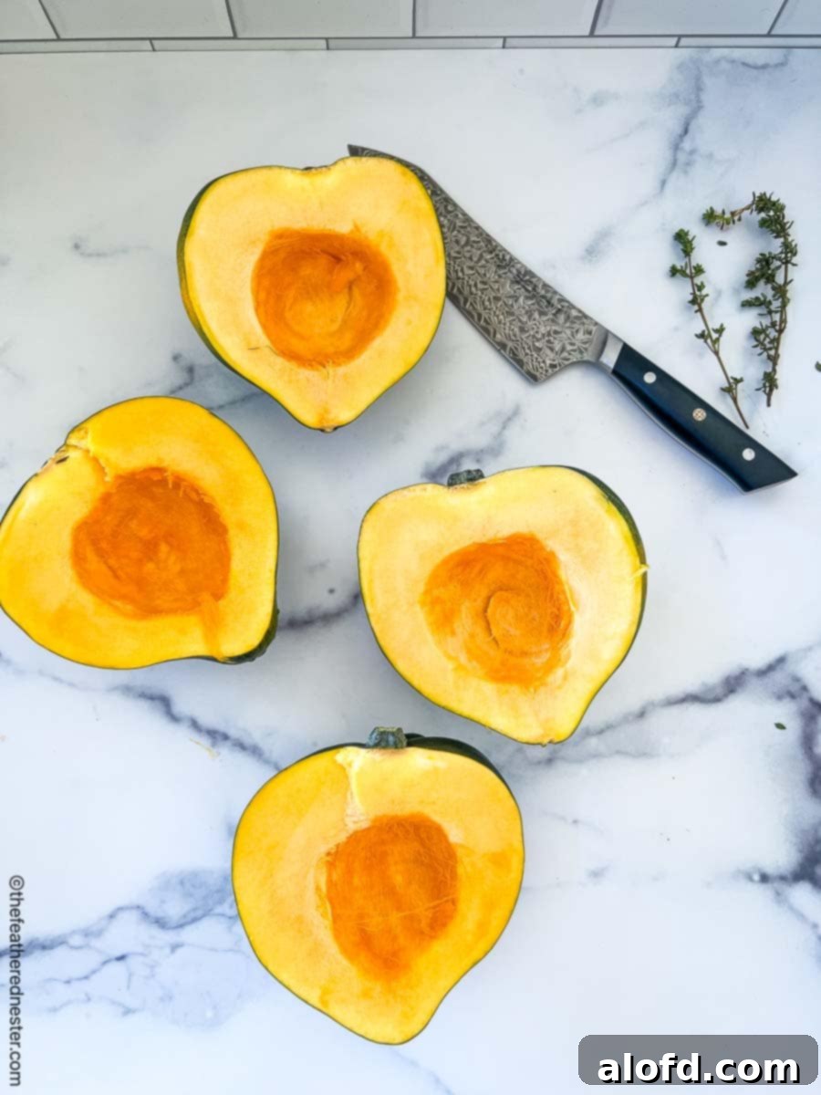 Creamy Instant Pot Acorn Squash Soup 6 A freshly cut acorn squash, revealing its bright orange flesh and seeds.
