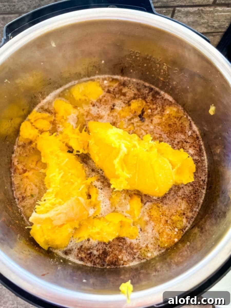 Creamy Instant Pot Acorn Squash Soup 10 Winter squash and apple simmering in a pressure cooker with broth.