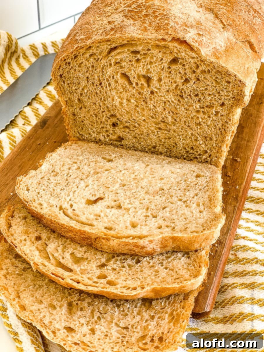 Beautifully baked whole wheat sourdough bread on top of a wooden board, ready to be sliced.