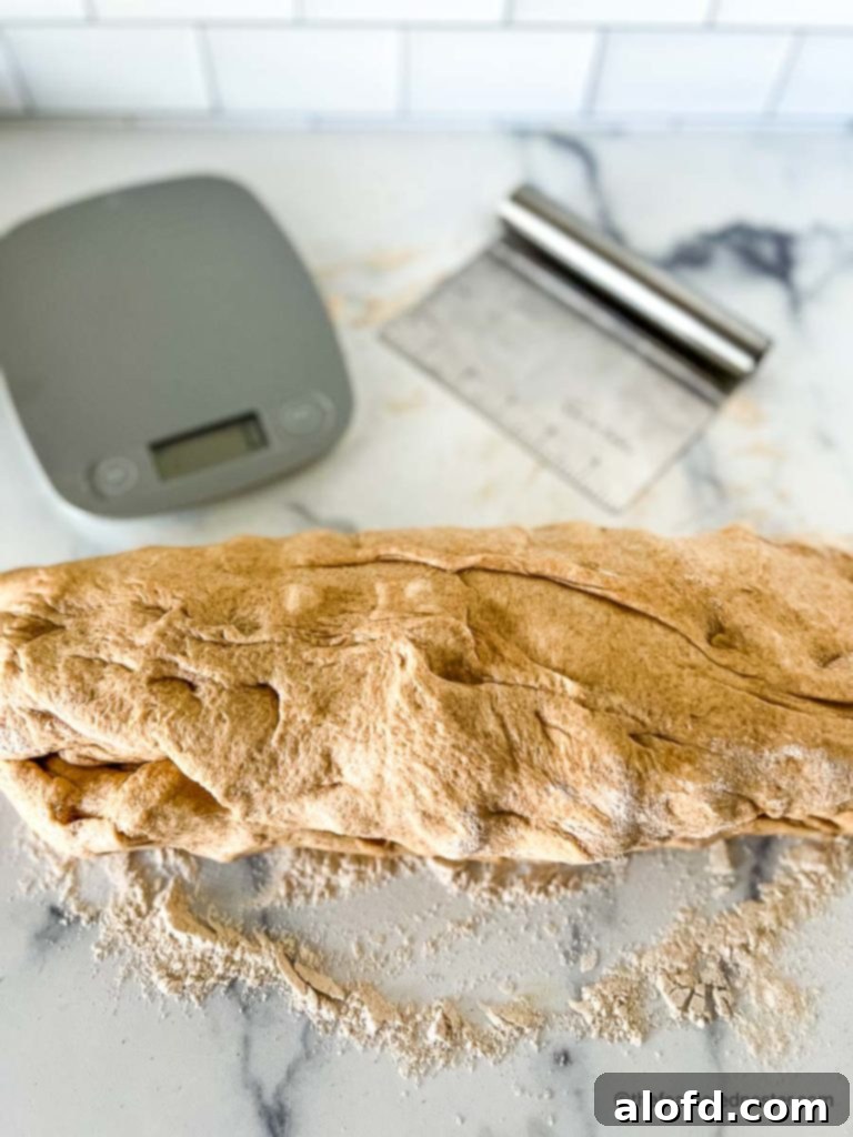The process of dividing a log of fresh bread dough, showing how to portion it for baking or for freezing individual balls of dough for later use.