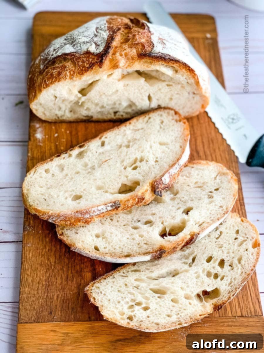 Slices of golden-brown sourdough garlic bread arranged on a rustic wooden cutting board, showcasing its chewy interior and crispy crust.