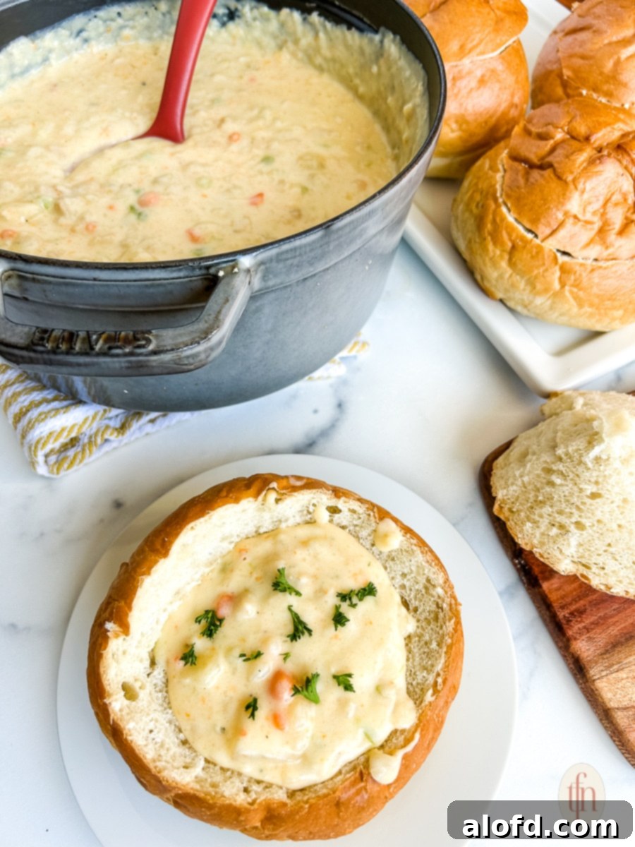 San Francisco Clam Chowder in a bread bowl on a white plate, ready to be enjoyed.
