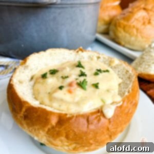 San Francisco Clam Chowder in a bread bowl on a white plate, ready to be enjoyed.