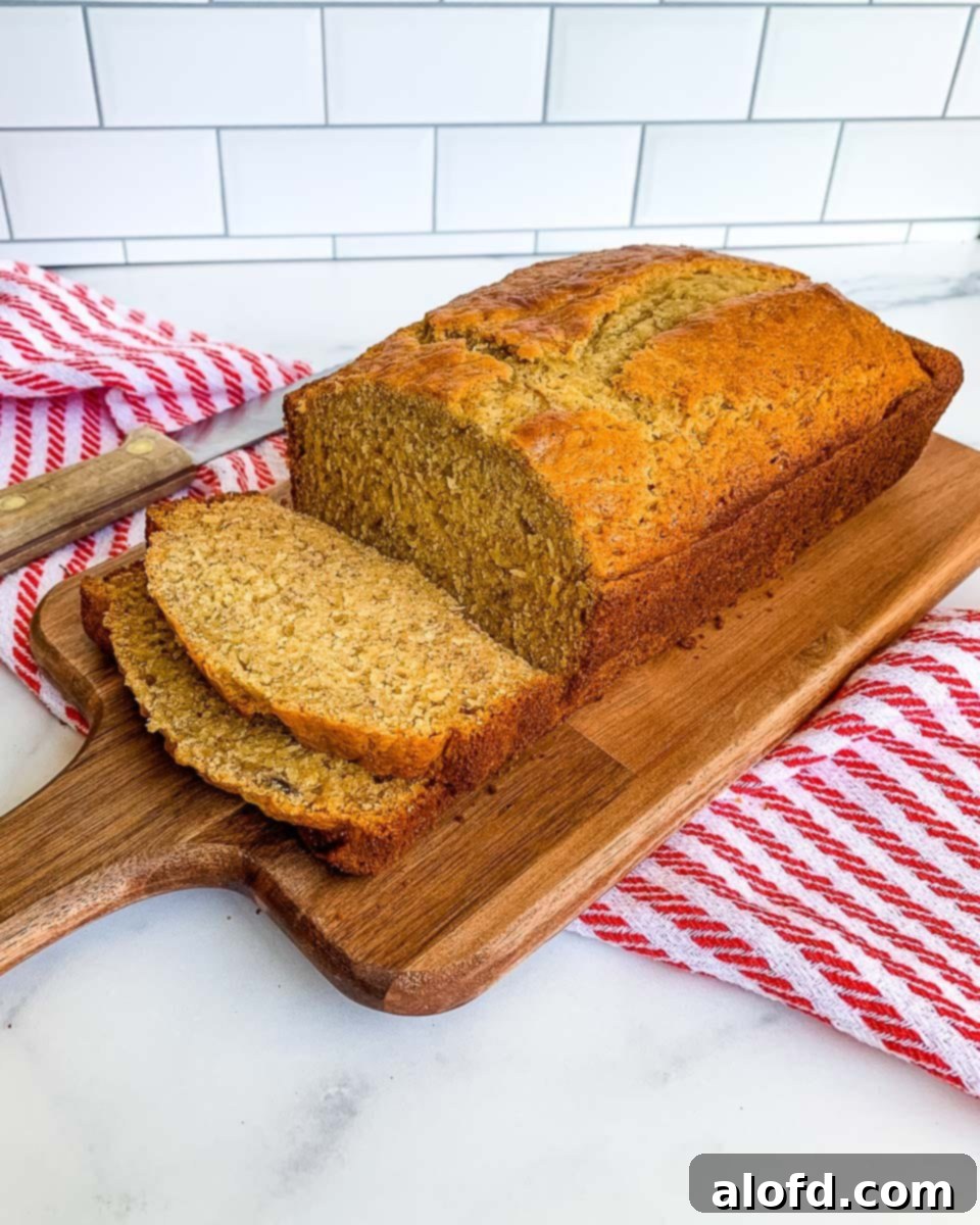 Effortless Self-Rising Banana Bread 2 Sliced banana bread recipe with self rising flour ready to serve from a wooden board with a red and white napkin.
