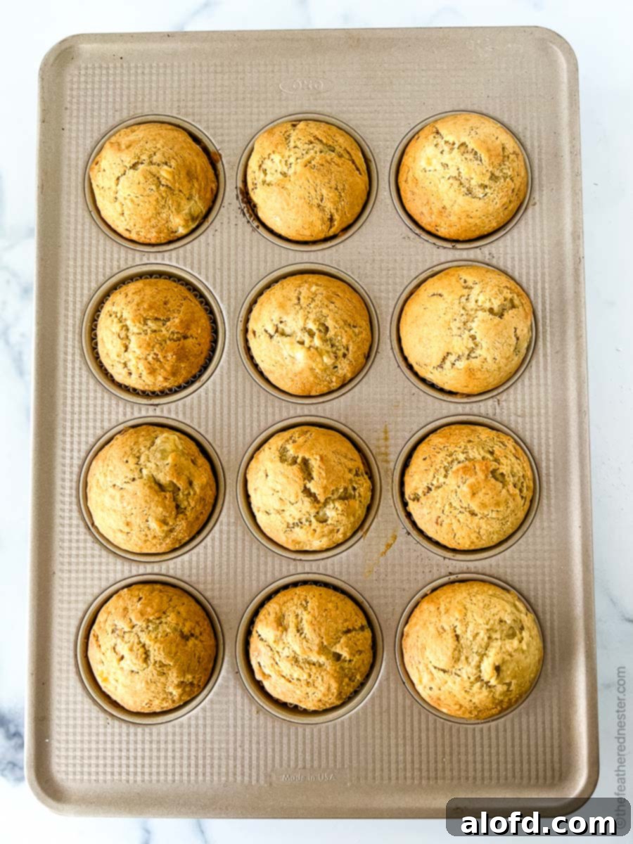 Freshly baked Bisquick banana muffins cooling on a wire rack, still steaming slightly.