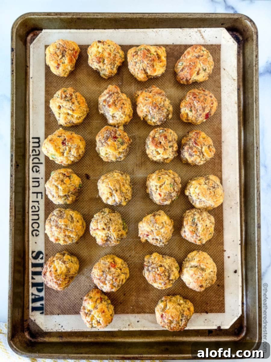 Baked pimento cheese sausage balls cooling on a baking sheet.
