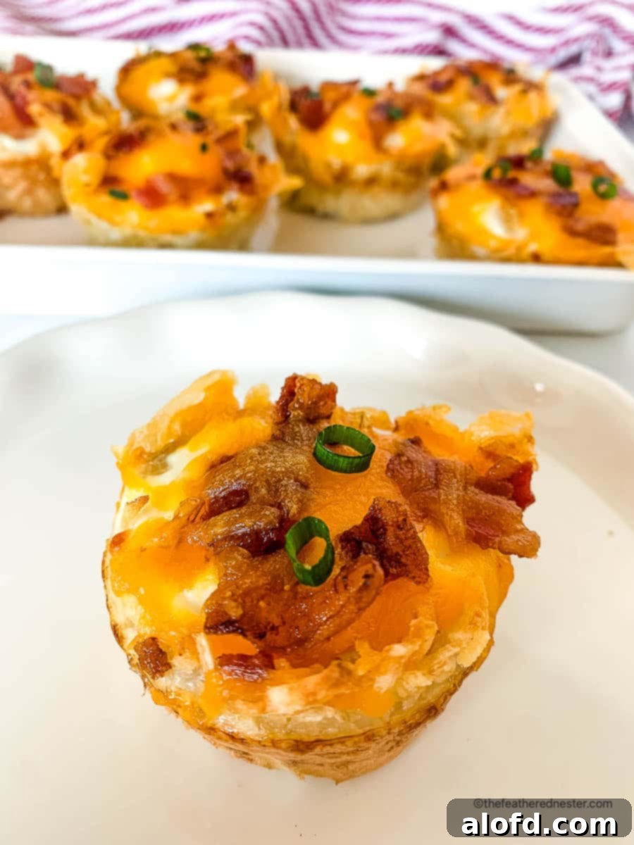 Crispy Hash Brown Egg Cups 13 a white plate with garnished egg nest breakfast cup and a tray full of them at the back.