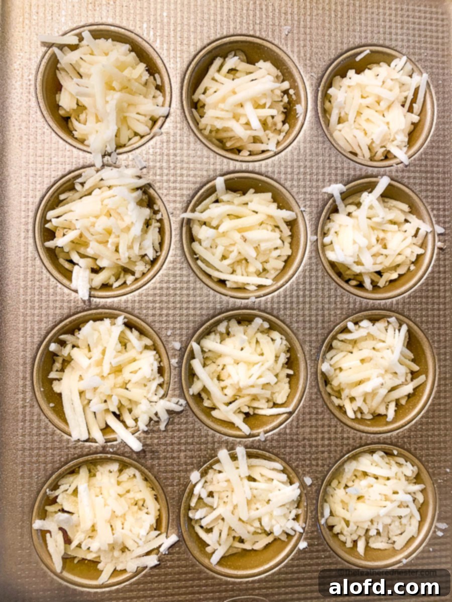 Crispy Hash Brown Egg Cups 6 Shredded potatoes in wells of a muffin pan.