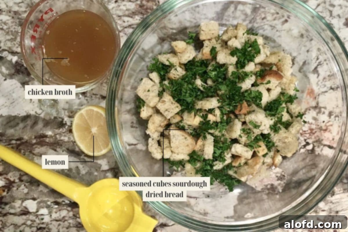 Savory Sourdough Stuffing 4 A collection of labeled ingredients for the Sourdough Stuffing recipe, clearly showcasing fresh herbs, dried bread cubes, and crisp vegetables.