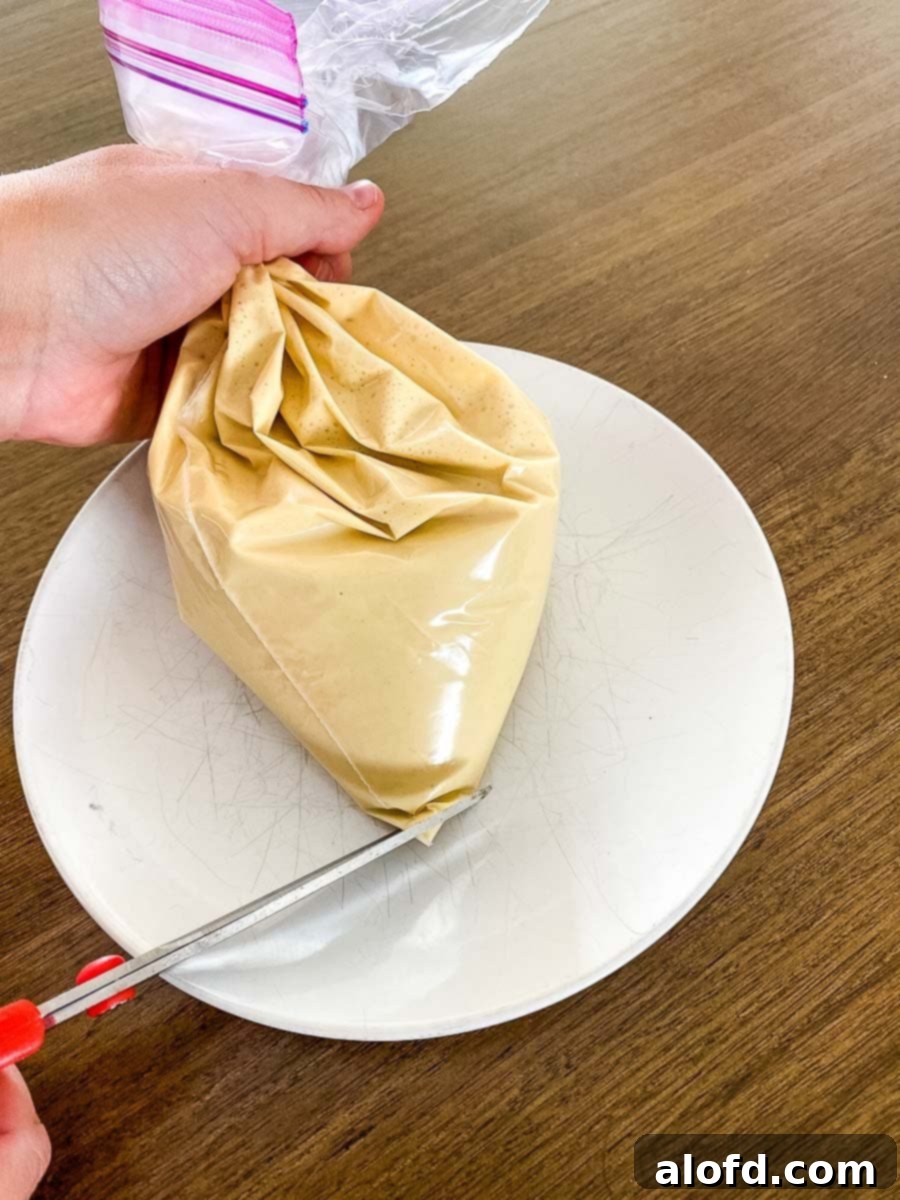 A Ziplock bag filled with smooth Bisquick funnel cake batter, ready for piping into hot oil.