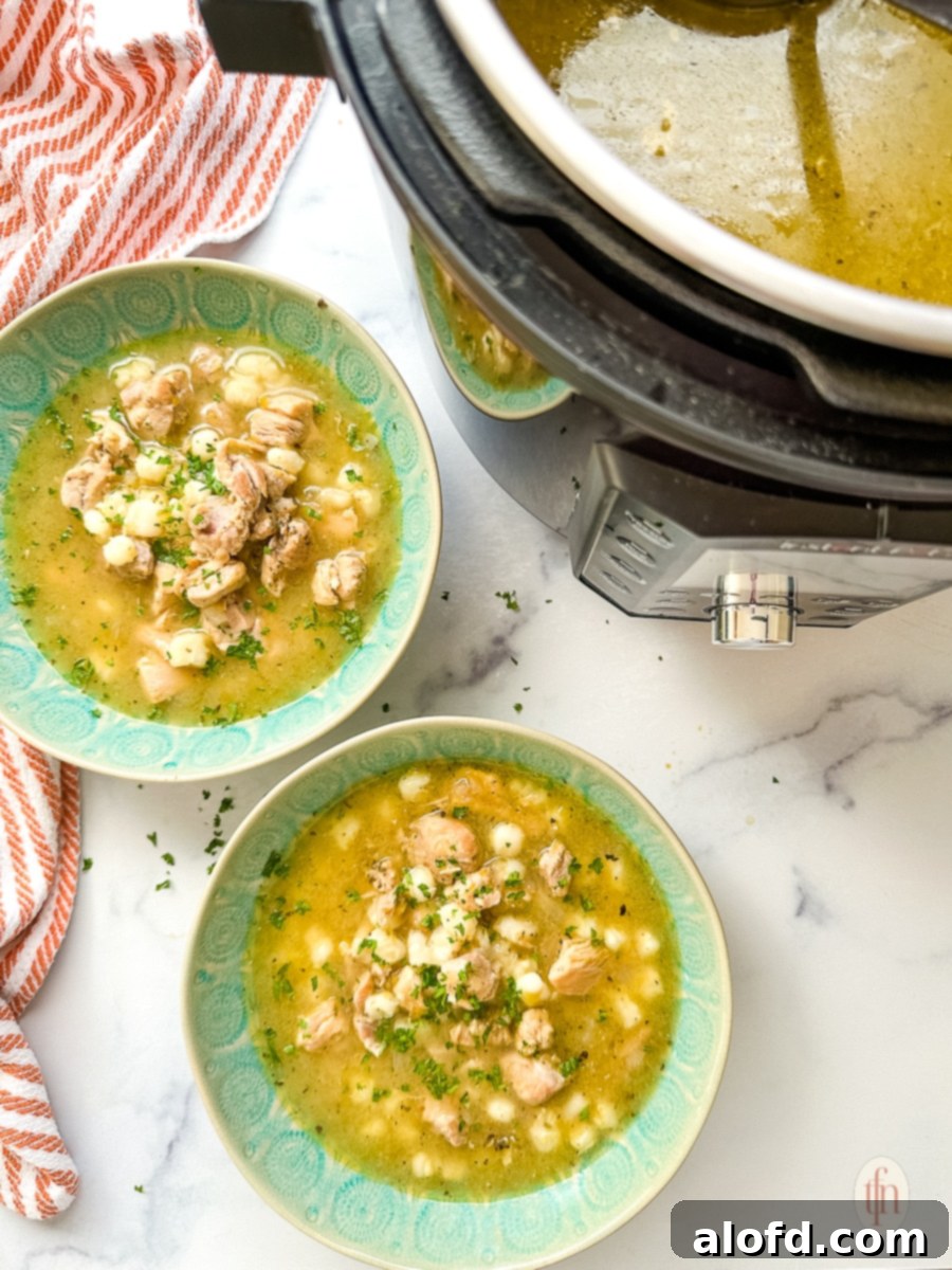 Speedy Instant Pot Pozole 10 Two steaming bowls of Instant Pot Pozole Verde placed alongside the Instant Pot itself, ready for serving.