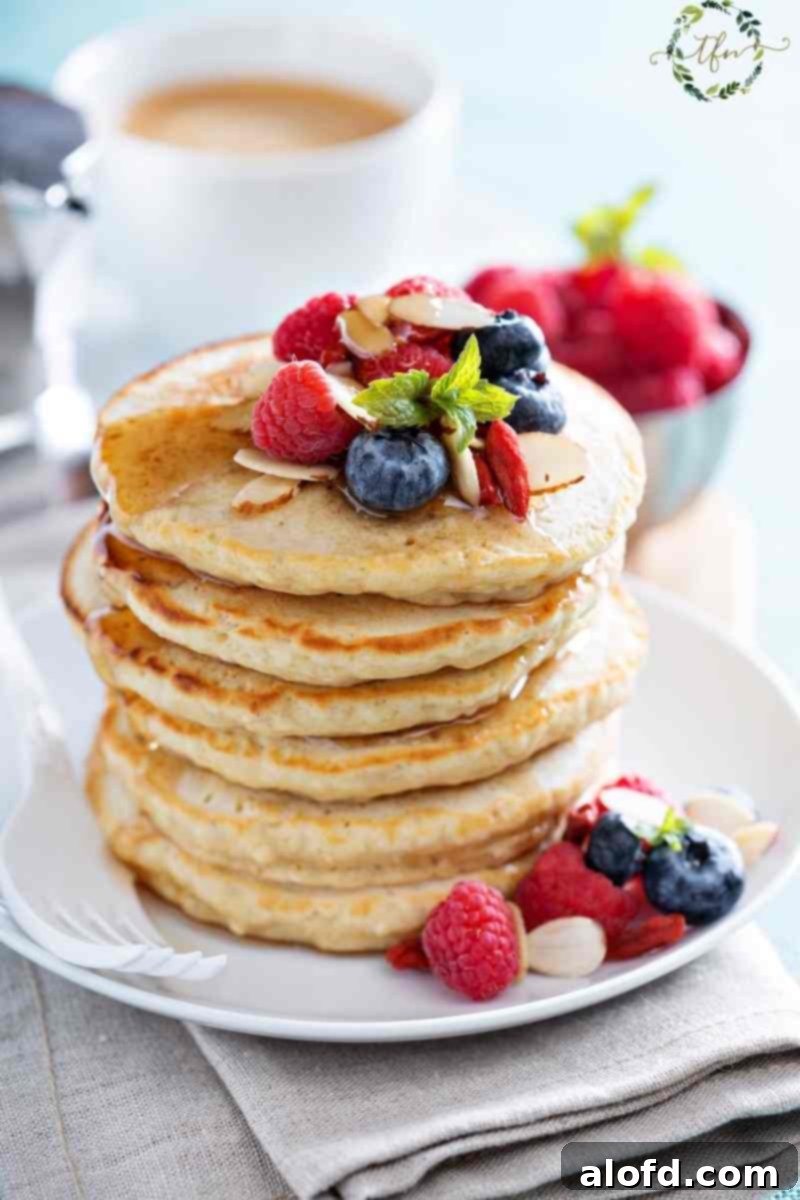 A stack of sourdough pancakes topped with fresh fruit.