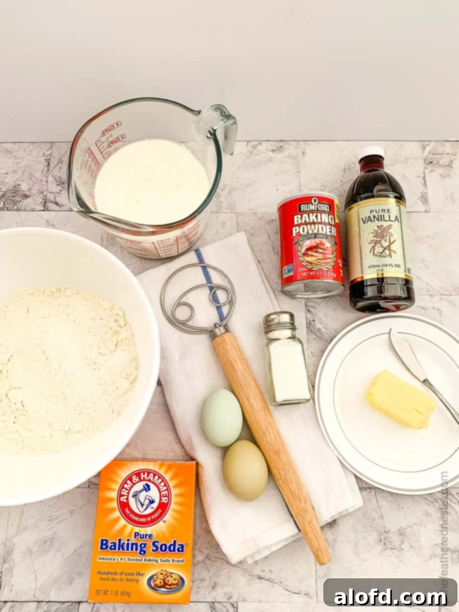 Ingredients for pancakes laid out on a surface with a dough whisk.