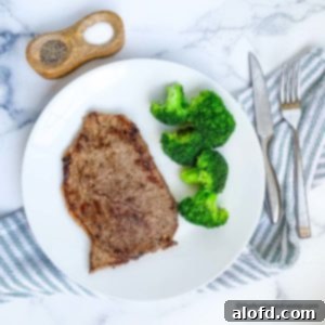 Sizzling Steaks on the Blackstone Griddle 10 steaks on blackstone griddle on a white plate with silverware and a napkin and seasonings.