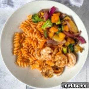 Vibrant Blackstone Veggies 10 A close-up of a white plate with perfectly cooked Blackstone Vegetables, served alongside pasta and shrimp, highlighting the crisp-tender texture.