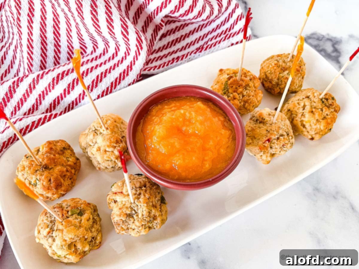 A tray of golden pimento cheese balls served alongside a generous bowl of vibrant sweet mango sauce, perfectly ready for dipping.