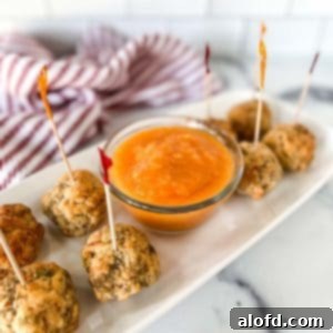 A platter of savory meatballs served alongside a bowl of vibrant chili mango sauce, showcasing a delicious pairing.