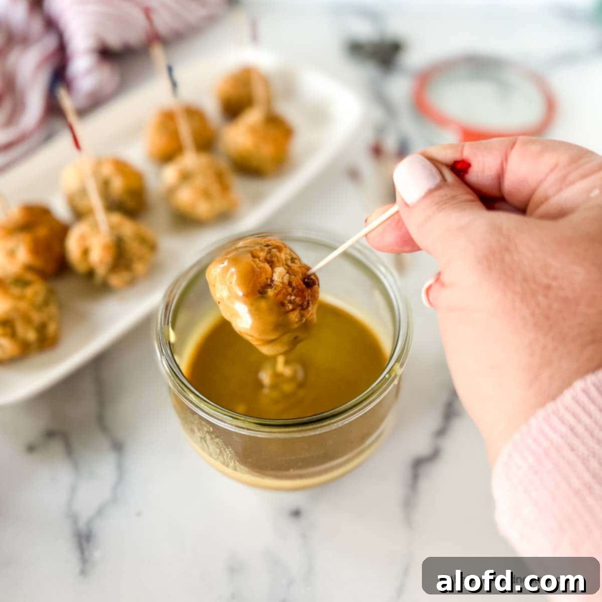 Zesty Honey Mustard Sauce 5 Dipping an appetizer ball into a Weck jar of spicy honey mustard sauce.